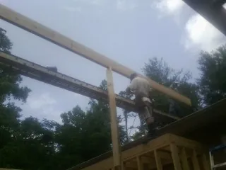 Carpenter setting a ridge beam over a new addition frame — Ice Dam Removal by Roofing Brothers in Sunburg