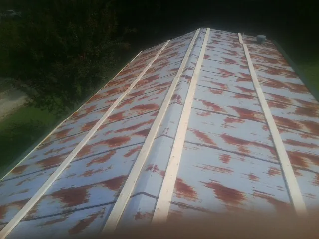 Rusted metal roof panels with new wood purlins before replacement — Storm Damage Roof Repair in Sunburg by Roofing Brothers